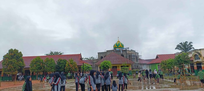 Siswa Madrasah Gotong Royong Bersihkan Genangan Air di lapangan